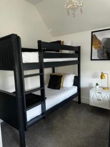 a bedroom with two bunk beds with white pillows at A gem close to Canford Cliff and Sandbanks beach in Parkstone