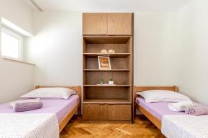 una camera con due letti e una libreria di Rooms Goreta a Kaštela (Castelli)