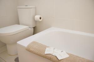 a bathroom with a toilet and a towel on a counter at Capitain Beachside Haven in Acantilado de los Gigantes