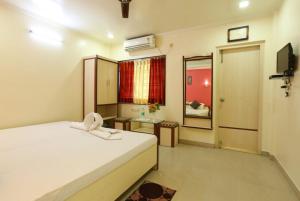 sypialnia z białym łóżkiem i lustrem w obiekcie Hotel Mira international - Luxury Stay - Best Hotel in digha w mieście Digha