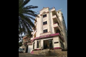 ディガにあるHotel Mira international - Luxury Stay - Best Hotel in dighaの白い高いピンクの縁取りの建物