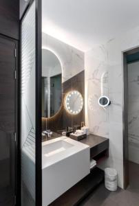 a bathroom with a white sink and a mirror at Hyatt Centric Jumeirah - Dubai Twin Room - UAE in Dubai