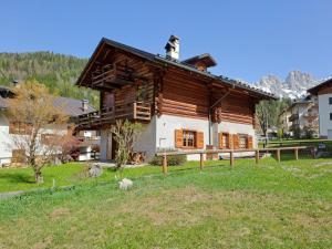 a large wooden house in the middle of a field at Tabia Maredane in Falcade