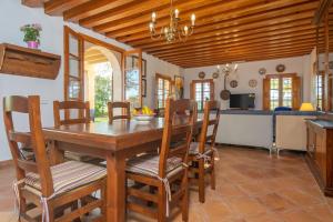 een keuken en eetkamer met een houten tafel en stoelen bij Can Pintat in Cala Anguila