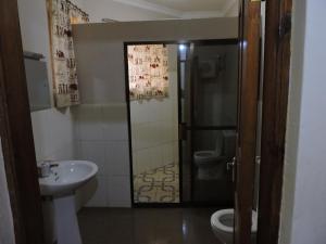 La salle de bains est pourvue d'un lavabo et de toilettes. dans l'établissement KLH REST HOUSE, à Karatu