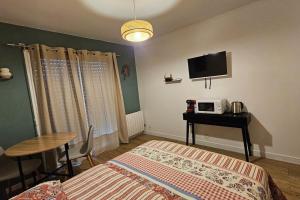 a bedroom with a bed and a table and a tv at Studio avec jardin et parking 04 in Villenave-dʼOrnon