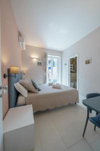 a white bedroom with a bed and a chair at B&B Lerici Al Mare in Lerici