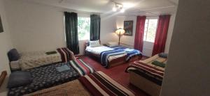 Habitación de hotel con 2 camas y sofá en Millgate Cottage, en Balgowan