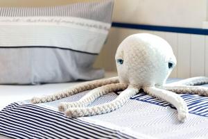 een gevulde octopus zit op een bed bij Käptn ADI in Groß Kirr