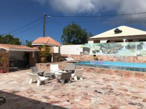 a patio with chairs and a swimming pool at Villa Guadeloupe standing in Le Moule