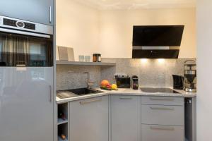 a kitchen with white cabinets and a white refrigerator at Kleine Lagune in Zingst