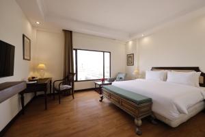 Ein Bett oder Betten in einem Zimmer der Unterkunft V Sarovar Portico MI Road Jaipur