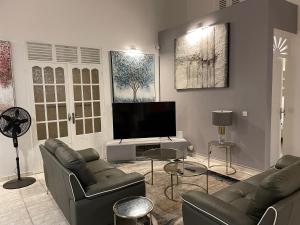 a living room with two couches and a flat screen tv at Villa Guadeloupe standing in Le Moule