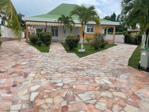 a house with a stone driveway in front of a house at Villa Guadeloupe standing in Le Moule