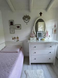 a bedroom with a bed and a dresser with a mirror at The house between the lakes in Laino