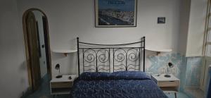 a bedroom with a blue bed and two night stands at Piccolo Tirreno Hotel Residence in Procida
