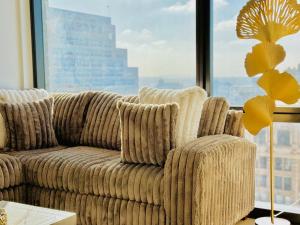 a couch in a living room with a large window at Relax On The Penthouse Floor DTLA With A View in Los Angeles