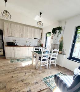 a kitchen and dining room with a table and chairs at Apartament Eminescu 2 in Zărneşti +7 photos