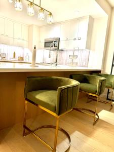 uma cozinha com duas cadeiras verdes e um balcão em Relax On The Penthouse Floor DTLA With A View em Los Angeles
