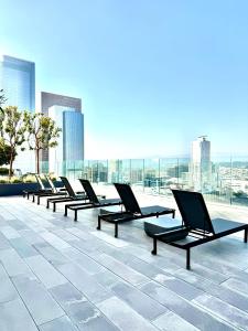 洛杉磯的住宿－Relax On The Penthouse Floor DTLA With A View，坐在大楼顶上的一排椅子
