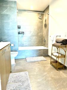 y baño con ducha, bañera y aseo. en Relax On The Penthouse Floor DTLA With A View en Los Ángeles