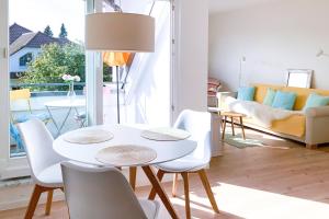 Kranichflug في زنغست: غرفة معيشة مع طاولة وكراسي بيضاء