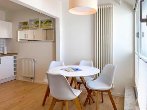 Kranichflug في زنغست: غرفة طعام مع طاولة بيضاء وكراسي بيضاء