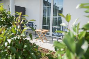 d'une terrasse avec des chaises et une table devant une fenêtre. dans l'établissement Taste Style Hotel Bären Auggen, à Auggen