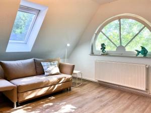 sala de estar con sofá y ventana abovedada en Kormoran 19, en Zingst