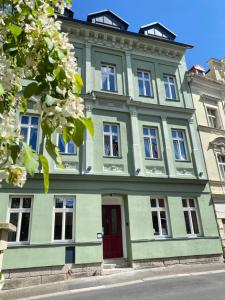 a large green building with a red door at CARLS AUTHENTIC B&B in Karlovy Vary