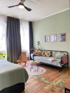 a bedroom with a bed and a couch and a fan at CARLS AUTHENTIC B&B in Karlovy Vary