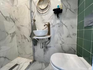 une salle de bain avec un lavabo, des toilettes et un miroir dans l'établissement Just Sezimbra, à Sesimbra 18 autres photos