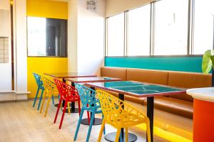 a row of tables and chairs in a restaurant at L MINITEL at Night Bazaar Chiangmai in Chiang Mai