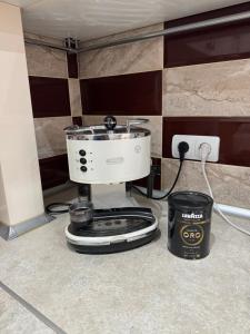a slow cooker sitting on a kitchen floor next to a wall at Dendrarium Park Apartament in Chişinău
