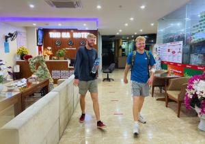 two men are standing in the lobby of a store at Thu Ha Hotel in Uông Bí