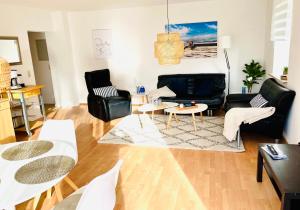 a living room with black furniture and a table at Feriengut Neuhof in Fehmarn