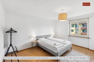 - une chambre blanche avec un lit et une fenêtre dans l'établissement Zurich 2-Bedroom Apartment with Comforts, à Zurich