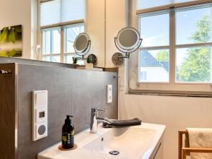 een badkamer met een wastafel en 2 spiegels aan de muur bij Ocean Star in Zingst