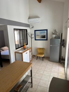 a room with a desk and a table and a chair at HOLIDAYLAND BAIE DES OLIVIERS VILLA 36m2 1chambre fermée 6 couchages ou VILLA 41M2 2chambres fermées 7 couchages in Narbonne-Plage