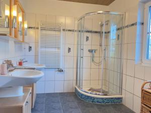 a bathroom with a glass shower and two sinks at Ostseeschwimmer in Wieck