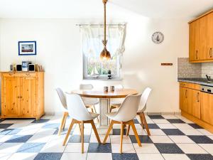 a kitchen with a wooden table and white chairs at Ostseeschwimmer in Wieck