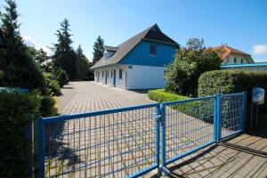 a blue fence in front of a house at Ostseeschwimmer in Wieck