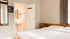 biała sypialnia z łóżkiem i umywalką w obiekcie Town Lodge w Newquay
