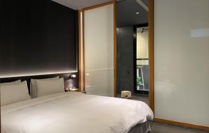 泰安鄉的住宿－泰安觀止溫泉會館，卧室配有一张白色大床和镜子