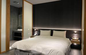 泰安鄉的住宿－泰安觀止溫泉會館，卧室配有一张白色大床和镜子