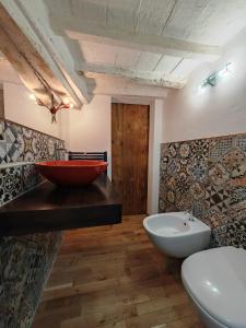 bagno con lavandino rosso e servizi igienici di Jolie Maison au coeur de Parma avec Parking privé inclusif a Parma