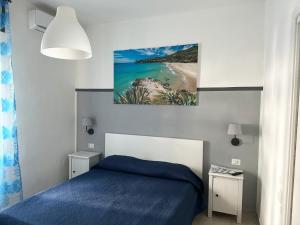 ein Schlafzimmer mit einem blauen Bett und einem Strand in der Unterkunft Mareluna Bed and Breakfast in Marina di Camerota