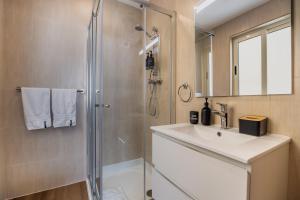 ein Bad mit einer Dusche und einem Waschbecken in der Unterkunft The Howard Hotel in Sliema