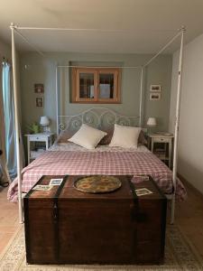 a bedroom with a canopy bed with a wooden trunk at The house between the lakes in Laino