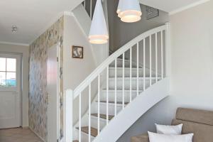 - un escalier blanc avec des balustrades blanches dans le salon dans l'établissement Sonnenschein, à Zingst